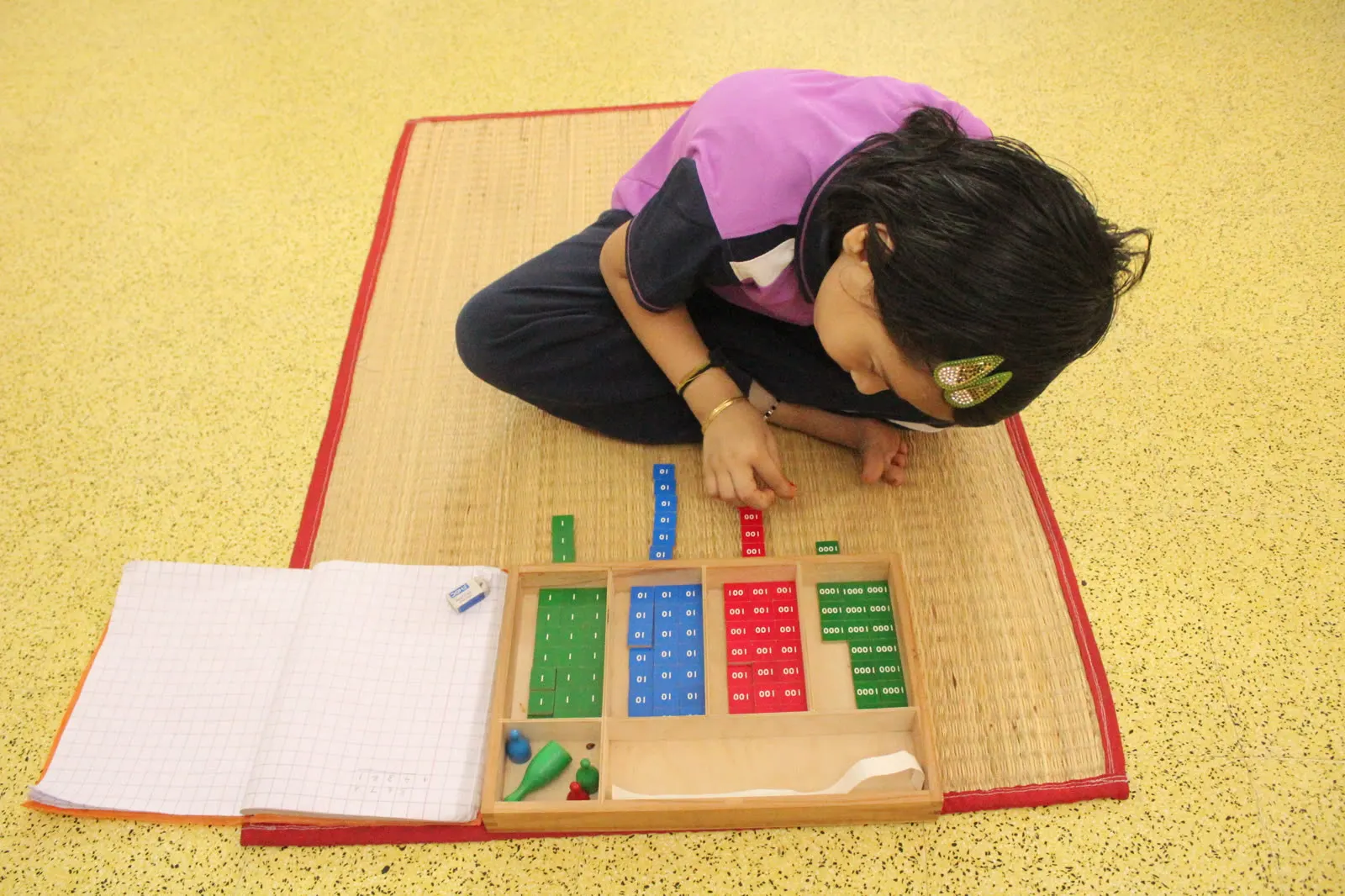 A child doing place-value maths with the Montessori stamp game