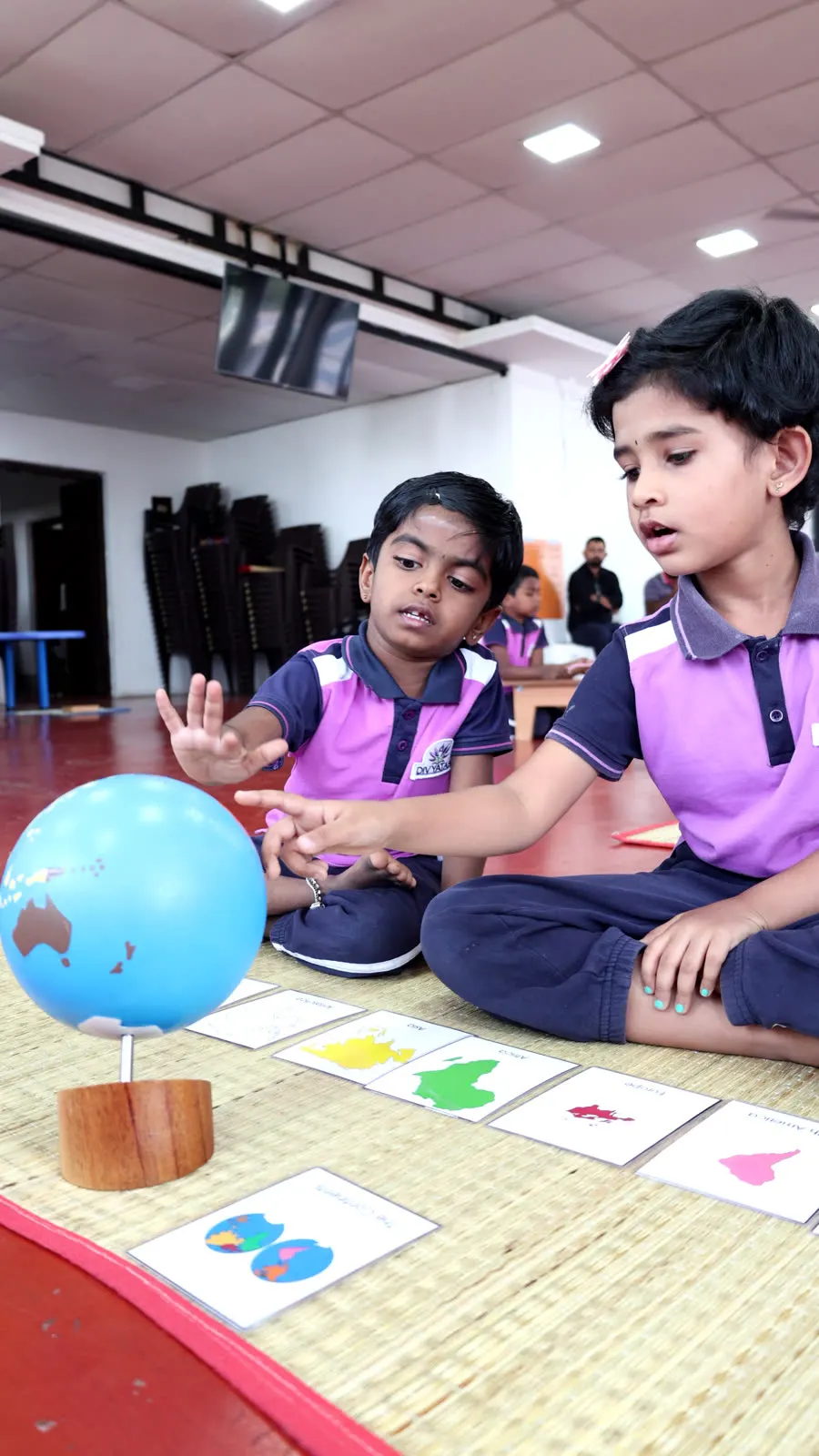 Two children exploring continents on a Montessori globe